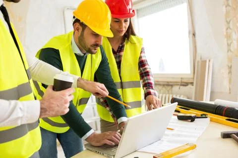 Architects using laptop at construction site Stock Photos