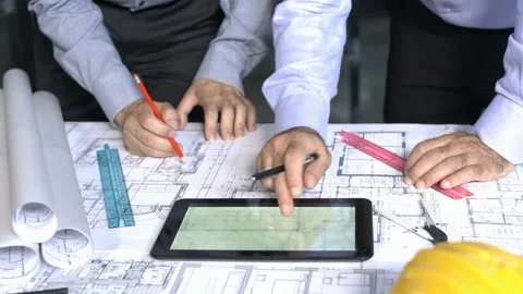 Architects working on blueprints And Tablets Stock Footage 210479320