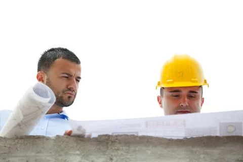 Architects working on their construction plan on the construction site Stock Photos