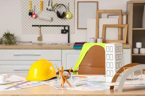 Architect's workplace with hardhat, 3D models and color palettes in office Stock Photos