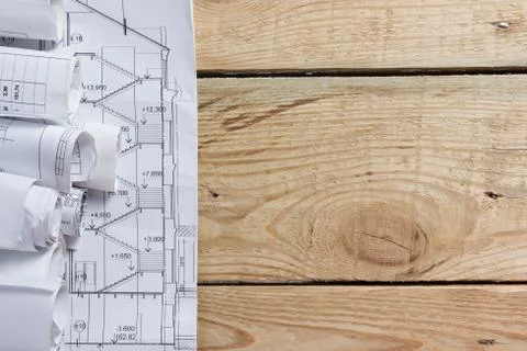 Architectural blueprints and blueprint rolls on wooden background Stock Photos