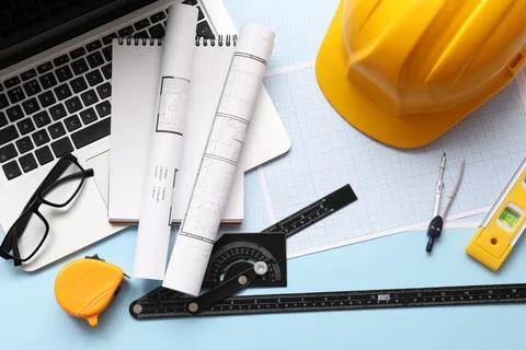Architectural blueprints and construction tools with a laptop and hard hat on Stock Photos