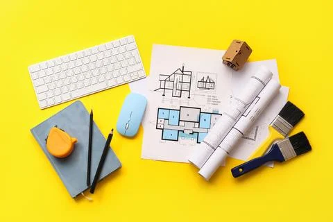 Architectural blueprints and tools on yellow background with keyboard and mou Stock Photos