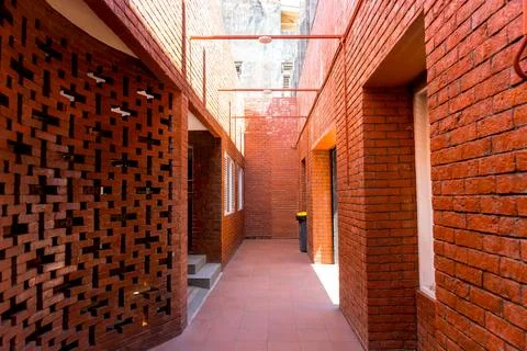 Architectural brick corridor with geometric screen walls and warm sunlight Фото