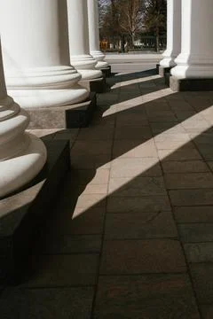 Architectural Columns Casting Shadows on Pavement Stock Photos