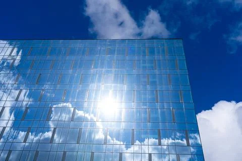 Architectural detail of the facade with multiple reflections of cloudy sky an Stock Photos