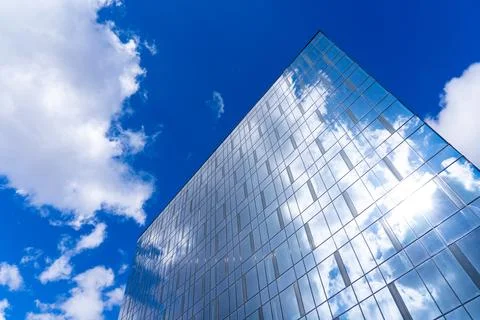 Architectural detail of the facade with multiple reflections of cloudy sky an Stockfoto's
