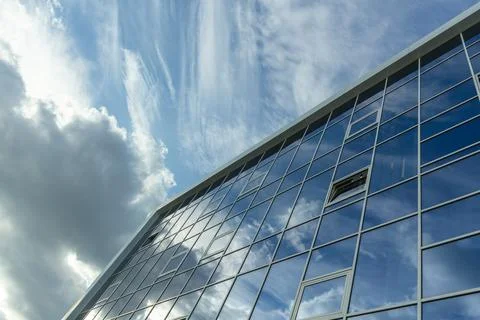 Architectural detail of the facade with multiple reflections of cloudy sky an Stock Photos