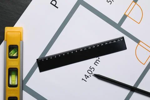 Architectural drawing, building level, ruler and pencil on grey table, flat l Fotos de archivo