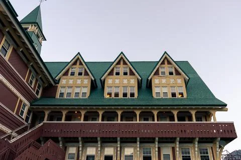 Architectural facade of a building with dormer windows and a green roof. Stock Photos