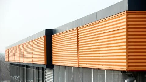 Architectural facade with orange cladding corrugated metal panels, large glas Stock Photos