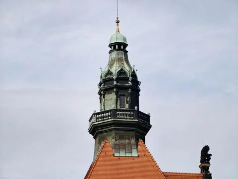 Architectural harmony between fiery red roof tiles and lush patina crowns i.. 库存照片