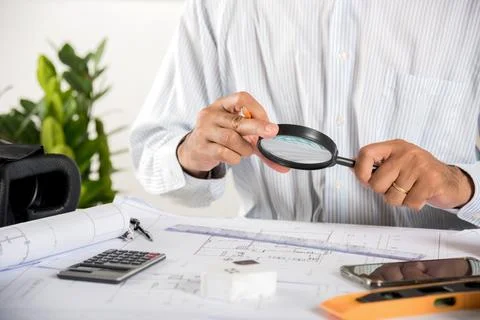 Architectural interior designer working holding magnifying glass and look on Stock Photos