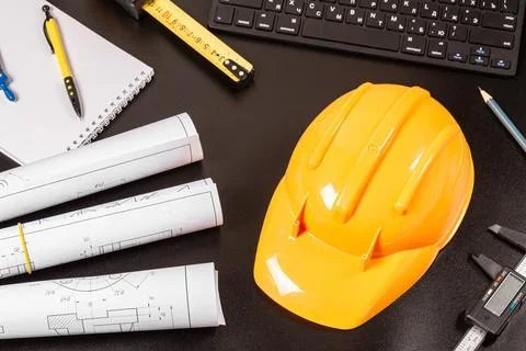Architectural or engineering profession background with hard hat and blueprin Stock Photos