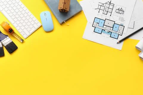 Architectural plans and tools on yellow workspace background Stock Photos