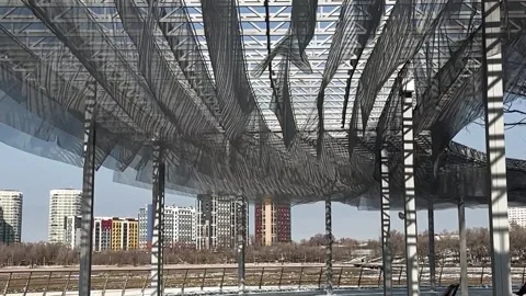 An architectural steel framework featuring a transparent mesh canopy Stock Footage 347169450