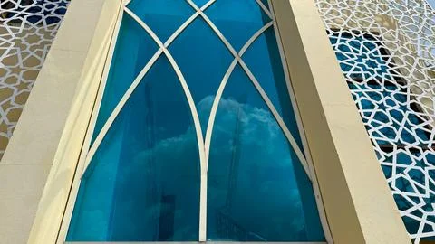 Architectural window showcasing geometric design with blue glass reflects sky Фото