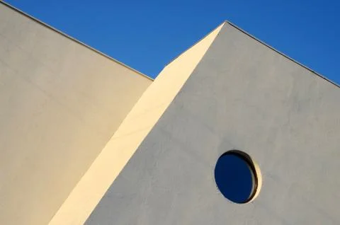 Architecture abstract wall with round window on blue sky background Stock Photos