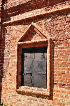 Architecture. A small window in the wall of an old monastery. Stock Photos