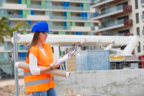 Architecture student checking blueprints next to a construction site Stock Photos