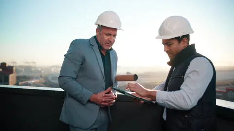 Architecture, tablet and talking with men on rooftop for city planning or Stock Footage 337926380