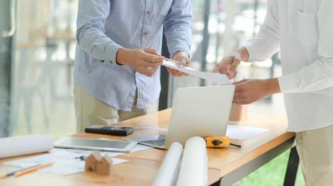 Architecture team is analyzing and designing houses with drawing devices plac 库存照片