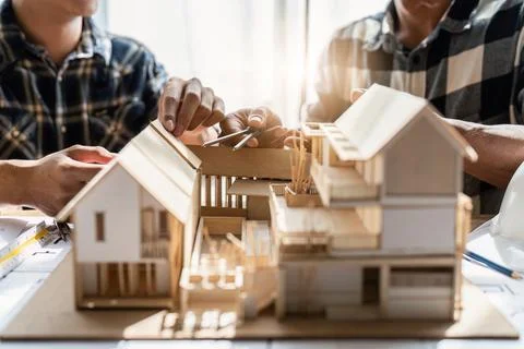 Architecture team drawing something while working with blueprint in the office Stock Photos