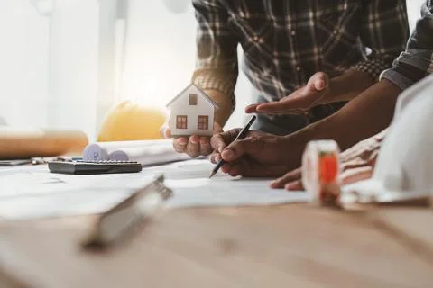 Architecture team drawing something while working with blueprint in the office Stock Photos