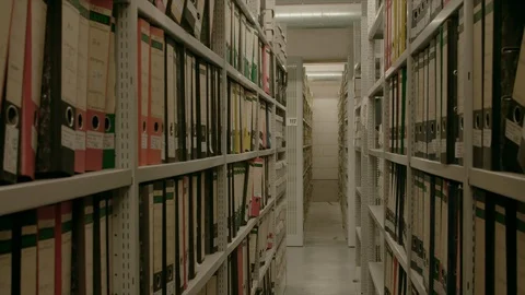 In an archive, between two shelf walls, the camera moves out. Видео 95430903