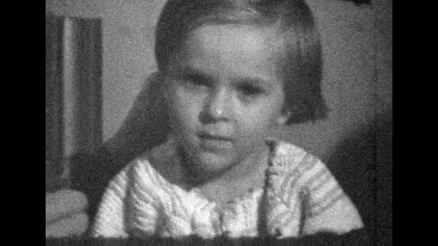 Archive film, little girl serious portrait looking at camera, close up. Creepy Stock Footage 276430230