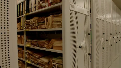 An archive with relocation shelves, the camera moves to a shelf with old files. Stock-Footage 95428233