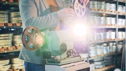 Archive worker is inserting film tape into the projector Vídeo Stock 147238661