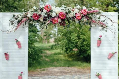 Archway of many beautifil flowers, wedding white arch with peones Stock Photos