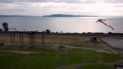 Arcing View Of Colorful Kite Overlooking The Water Vídeo Stock 155908520