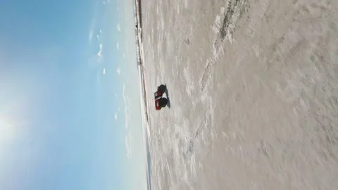 Arctic Rush. A car with large, low-pressure tires. Vertical 9x16 FPV Aerial Stock Footage 263080761