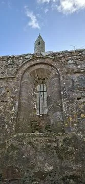 Ardmore Round Tower framed through ancient stone arch in Ireland Stock Photos