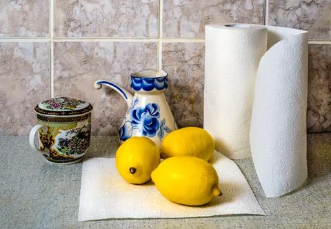 Area in our kitchen, on the table lemons on napkin, paper towel, and a Cup of Stock Photos