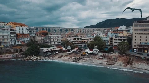 Areal view of a old broken boat garage with flying seagulls and aqueduct in back Stock Footage 130537293