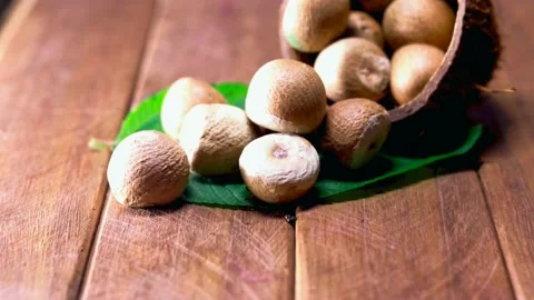 Areca nuts in wooden spoon with small green leaves,betel Nut or Areca Nut backgr Stock Footage 135747146