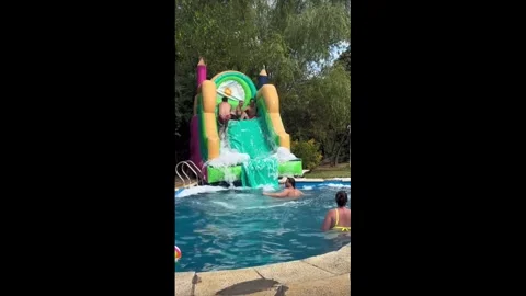 Argentina: Inflatable water slide tips over during poolside fun in Tigre,... Stock Footage 328664928