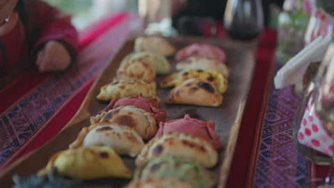 Argentina. Traditional empanadas over table at restaurant. People eating Stock Footage 338008473