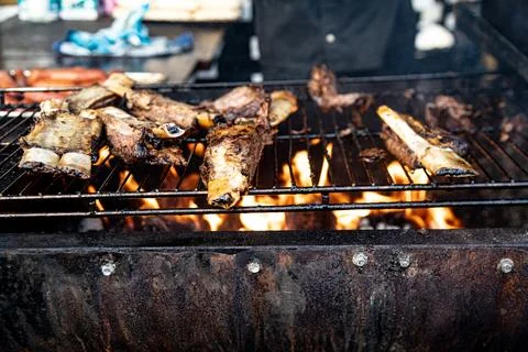 Argentinian bbq beef rigs being cooked and served in an event Foto stock