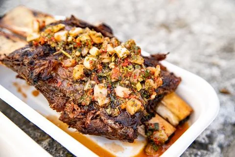 Argentinian bbq beef rigs being cooked and served in an event Stock-Fotos