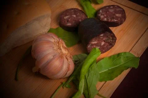 An argentinian black pudding with arugula, bread and garlic Foto stock