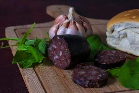 An argentinian black pudding with garlic, bread and arugula Stock Photos