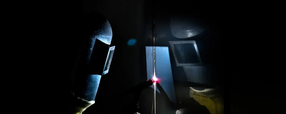 Argon welder uses torch to make sparks during manufacture of metal equipment Stock Photos
