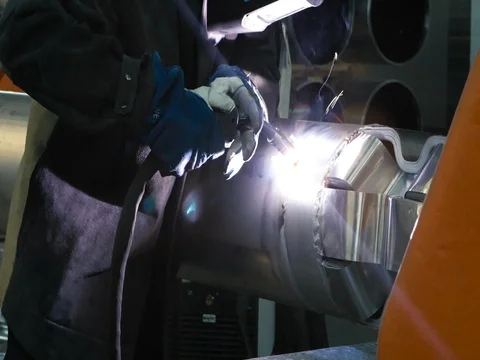 ARGON WELDING. A blacksmith or welder, with his welder, welding steel and iron Stock Footage 77935372