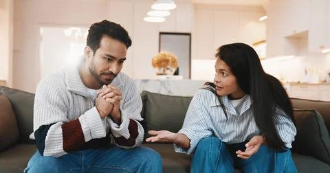 Argument, upset and couple on sofa in home for cheating, affair or divorce with Stock Photos
