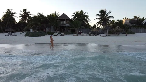 Arial Drone at Caribbean beach of young girl in bikini helix shot upwards Stock Footage 121692872