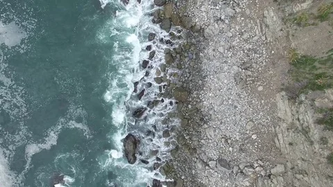 Arial Drone Overhead of Ocean and Beach with Rocks Stock Footage